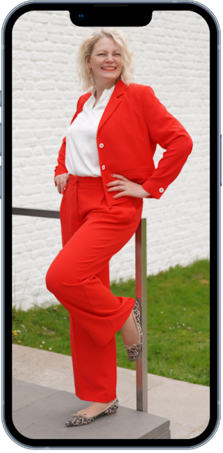 automatisiertes Onlinebusiness starten mit Jyotima Flak_handy rahmen Handy zeigt Jyotima flak stehend mit rotem Anzug, sie hilft coaches und therapeuten ein automatisiertes onlinebusiness mit Onlinekursen und passivem einkommen aufzubauen